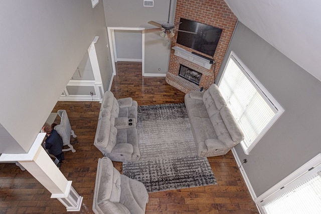 living room with lofted ceiling, a brick fireplace, and ceiling fan