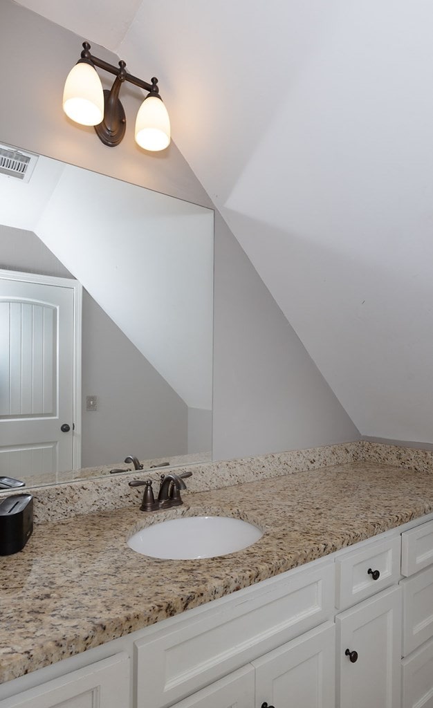 bathroom with vanity and vaulted ceiling