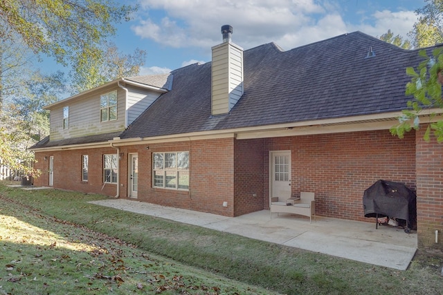 back of property with a patio and a lawn