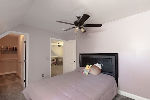 carpeted bedroom with ceiling fan, lofted ceiling, and a spacious closet