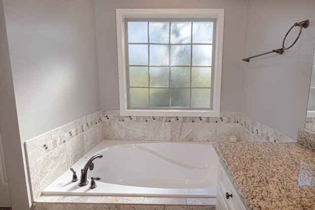 bathroom featuring vanity and tiled bath