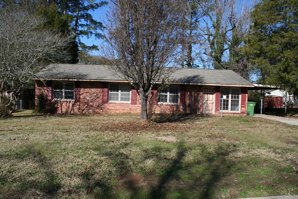 single story home featuring a front yard and a carport