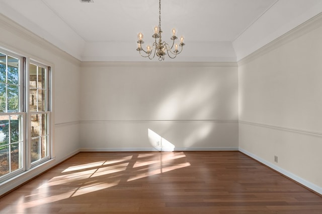 unfurnished room featuring a chandelier, wood-type flooring, and ornamental molding