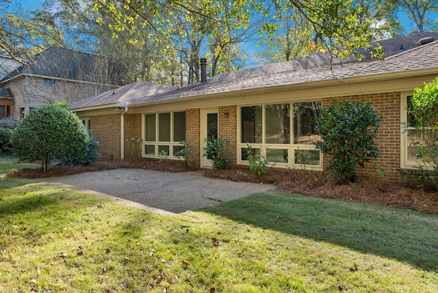 back of property featuring a lawn and a patio area