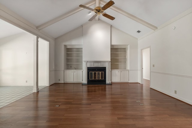 unfurnished living room featuring beamed ceiling, dark hardwood / wood-style floors, and built in features