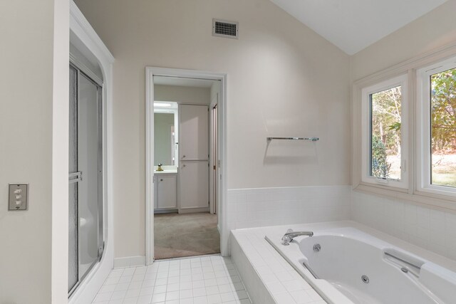 bathroom featuring plus walk in shower, tile patterned flooring, vanity, and vaulted ceiling