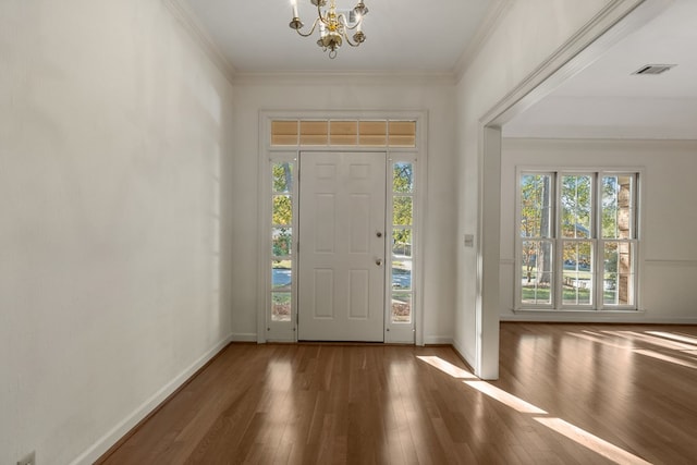 entrance foyer with hardwood / wood-style floors, a notable chandelier, and crown molding