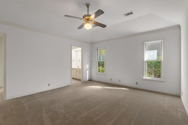 empty room featuring light colored carpet, vaulted ceiling, ceiling fan, and ornamental molding