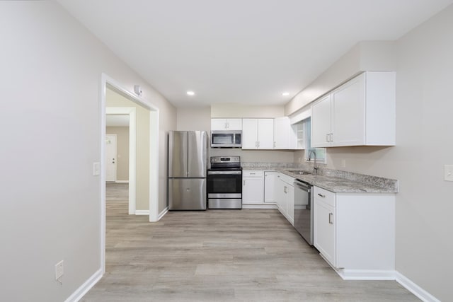 20 Benning Dell Dr, Columbus, GA 31903 - kitchen with stainless steel appliances, white cabinetry, light wood-style flooring, light stone counters, and recessed lighting