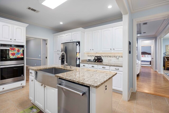 4730 Turnberry Ln Unit 15, Columbus, GA 31909 - kitchen featuring stainless steel appliances, crown molding, white cabinets, light stone counters, and light tile patterned floors