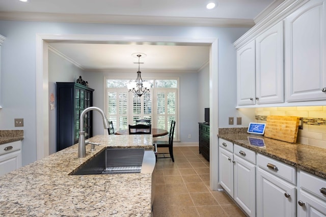 4730 Turnberry Ln Unit 15, Columbus, GA 31909 - kitchen featuring a chandelier, white cabinets, decorative backsplash, crown molding, and light stone countertops