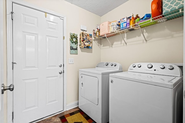 laundry room with laundry area, a textured ceiling, baseboards, and washer and dryer