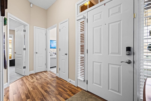 foyer with baseboards and wood finished floors