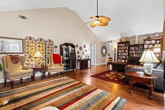 living room featuring high vaulted ceiling, wood finished floors, visible vents, baseboards, and a ceiling fan