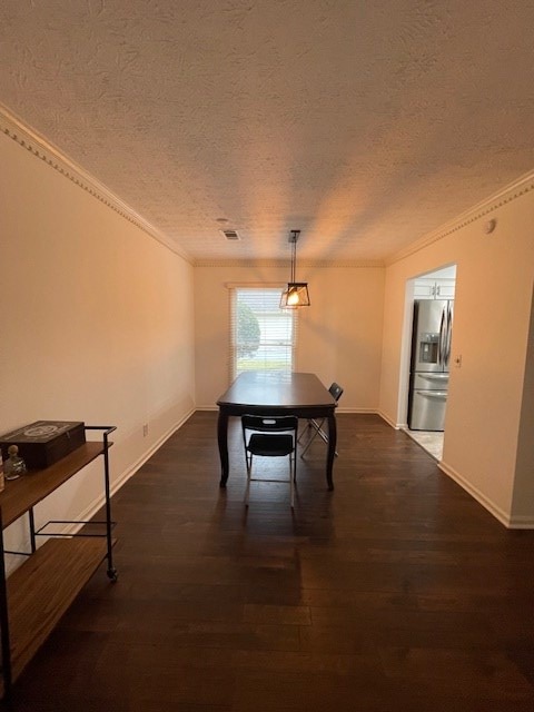 dining room with visible vents, crown molding, a textured ceiling, and dark wood-type flooring