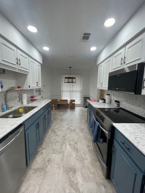 kitchen featuring visible vents, blue cabinetry, light countertops, stainless steel appliances, and a sink