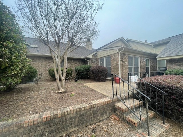 view of front of property with brick siding and a chimney