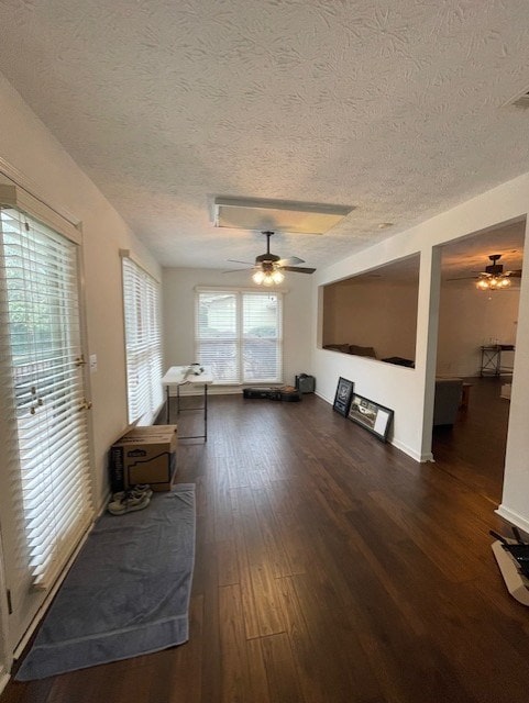 unfurnished living room with a textured ceiling, wood finished floors, and a ceiling fan