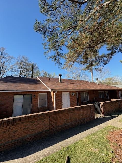 single story home with brick siding and a fenced front yard