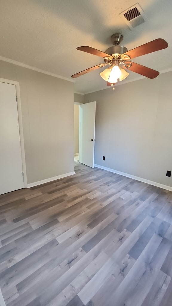 166 Pine Ridge Dr, Union Springs, AL 36089 - empty room with ceiling fan, baseboards, wood finished floors, and ornamental molding