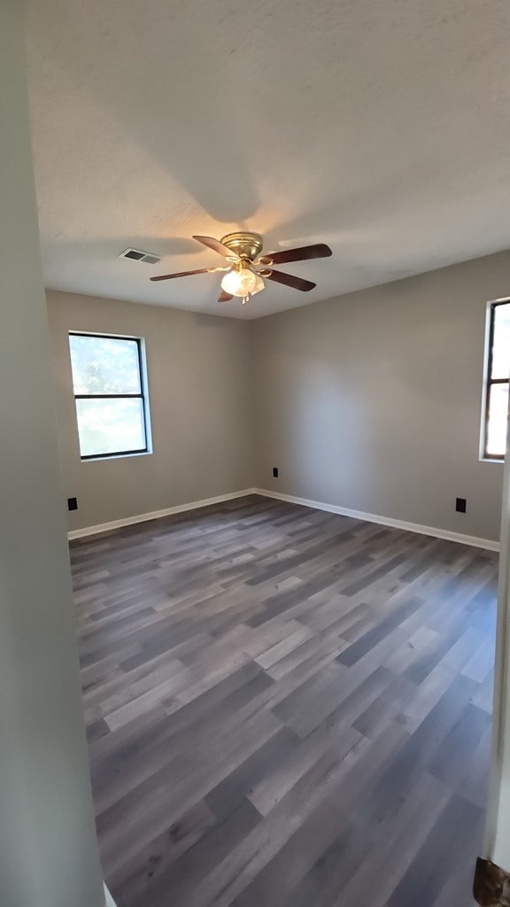 166 Pine Ridge Dr, Union Springs, AL 36089 - spare room featuring baseboards, a ceiling fan, and dark wood finished floors