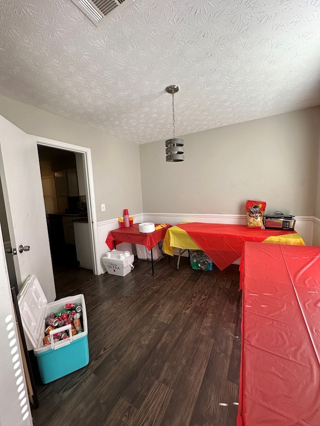 game room featuring visible vents, a textured ceiling, and wood finished floors