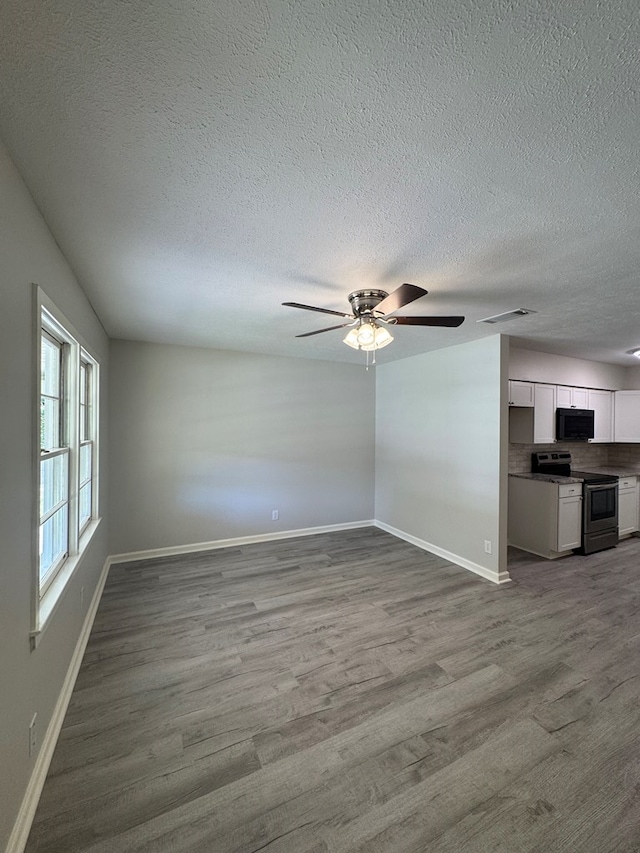 1508 Emerson Ave, Columbus, GA 31907 - unfurnished living room with wood finished floors, ceiling fan, and a textured ceiling