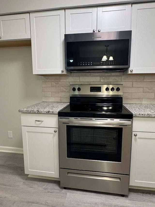 1508 Emerson Ave, Columbus, GA 31907 - kitchen featuring appliances with stainless steel finishes, light wood-style flooring, backsplash, and white cabinetry