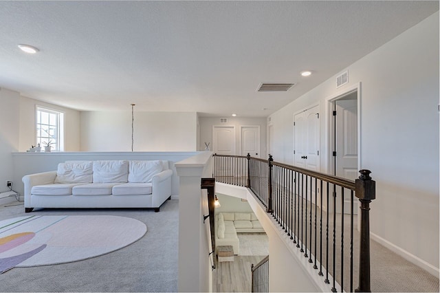 carpeted living area featuring visible vents, recessed lighting, and baseboards