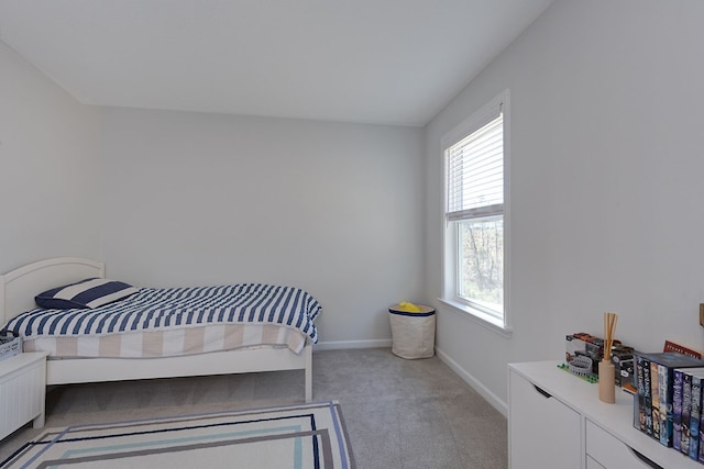 bedroom featuring light colored carpet and baseboards