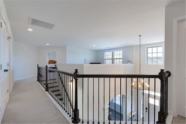 corridor with visible vents, an upstairs landing, recessed lighting, light colored carpet, and a chandelier