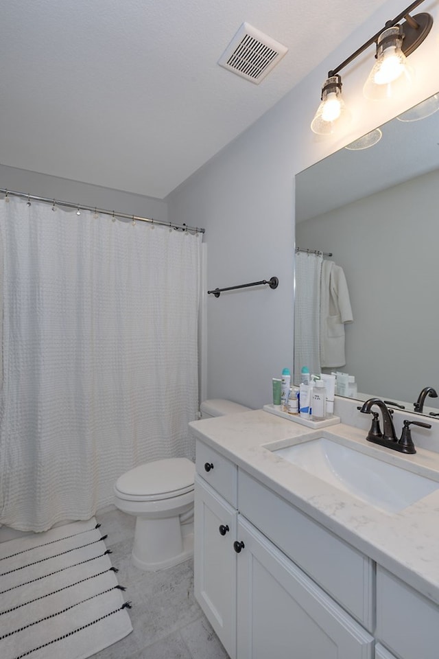 bathroom featuring visible vents, toilet, and vanity