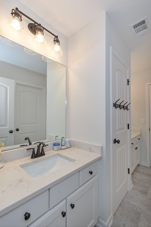 bathroom featuring visible vents, vanity, and baseboards