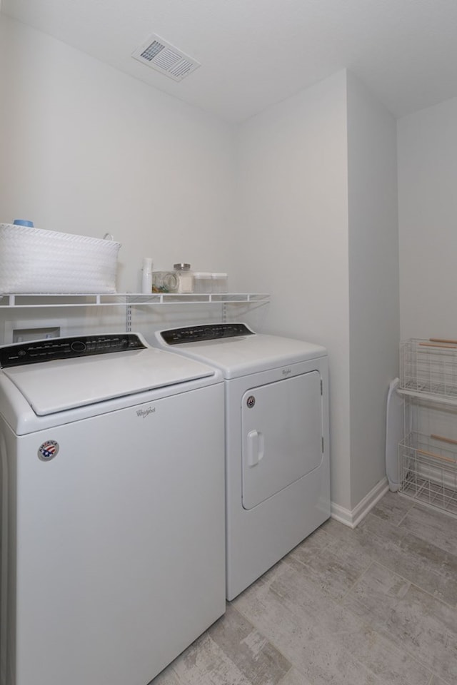 laundry area featuring visible vents, washing machine and dryer, laundry area, and baseboards