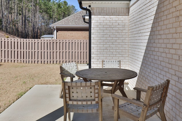 view of patio featuring outdoor dining space and fence