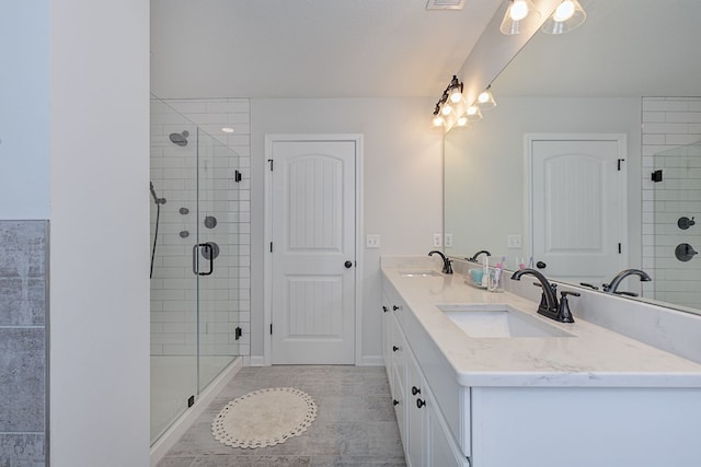 bathroom with double vanity, visible vents, a shower stall, and a sink