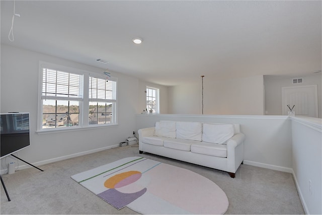 living area with visible vents, baseboards, and carpet floors