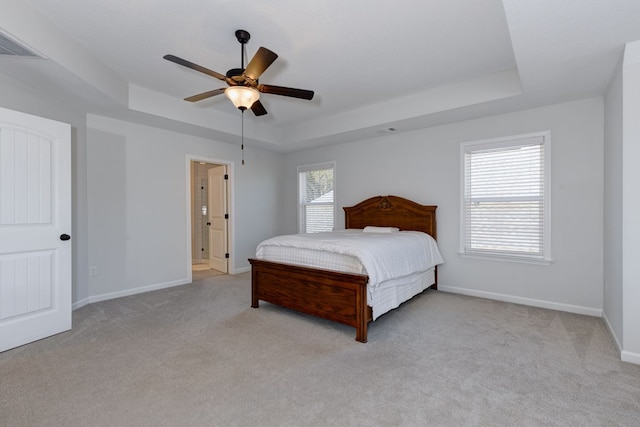 bedroom featuring a tray ceiling, baseboards, carpet floors, and visible vents