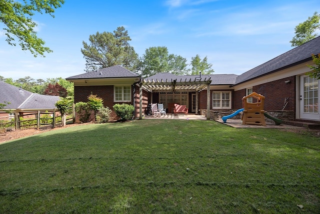 rear view of house with a pergola, a patio area, brick siding, roof with shingles, and a playground