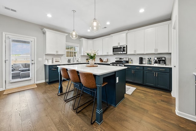 2013 Hereford Ln, Columbus, GA 31904 - kitchen with stainless steel appliances, white cabinets, a kitchen breakfast bar, dark wood finished floors, and recessed lighting
