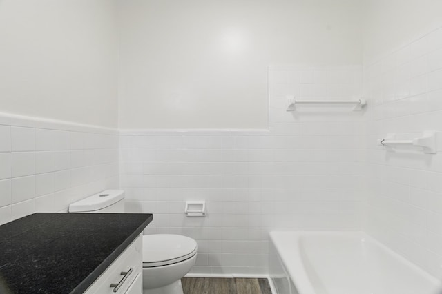 5202 Lakeshore Rd, Columbus, GA 31907 - bathroom with tile walls, wood finished floors, toilet, a bathtub, and vanity