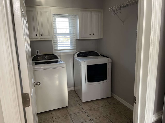 laundry room featuring cabinets, separate washer and dryer, and light tile patterned floors