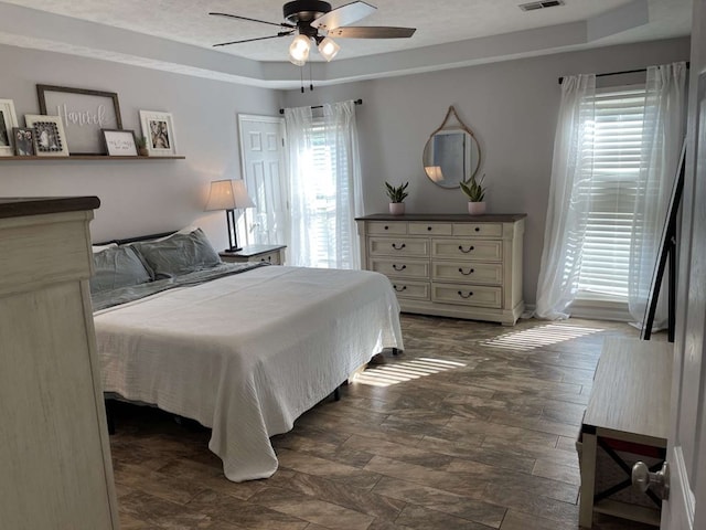 bedroom featuring a tray ceiling and ceiling fan