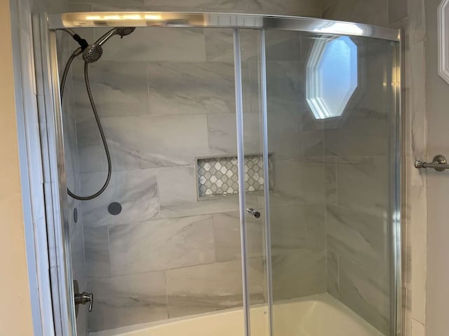 bathroom with bath / shower combo with glass door