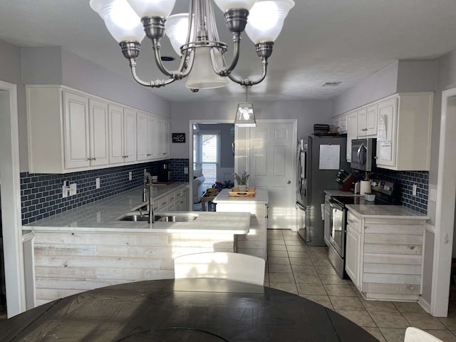 kitchen with pendant lighting, white cabinetry, sink, light tile patterned floors, and stainless steel appliances