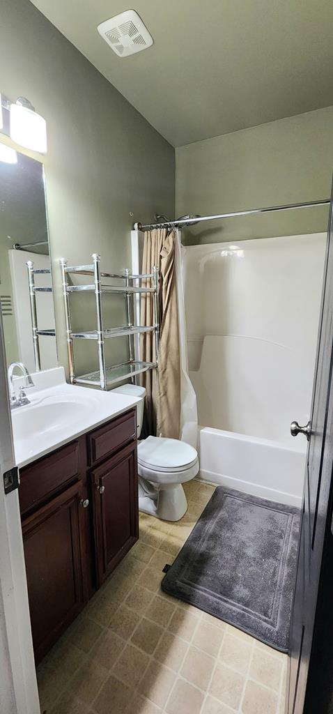 bathroom with toilet, visible vents, shower / tub combo with curtain, and vanity