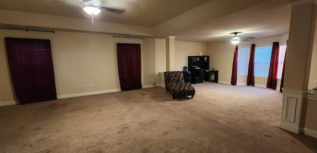 interior space with carpet, ceiling fan, and baseboards