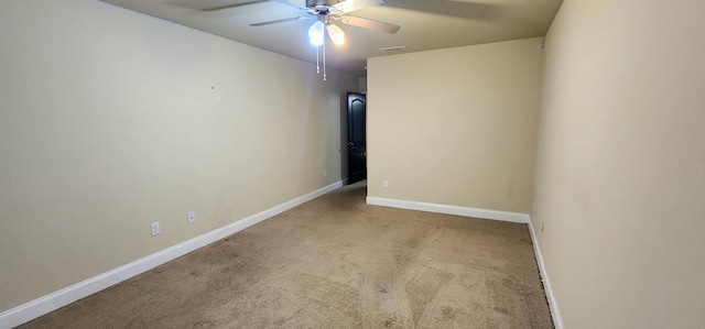 empty room featuring carpet, visible vents, baseboards, and ceiling fan