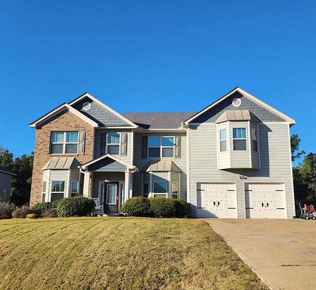 view of front of property with a garage, driveway, and a front lawn