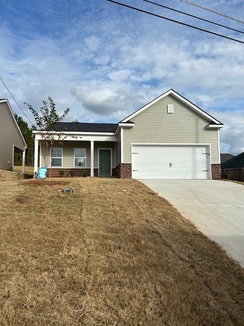 view of front of house with a garage, a front yard, and a porch